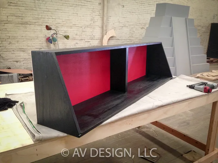 Black-stained display shelf unit with a red interior built in the shop