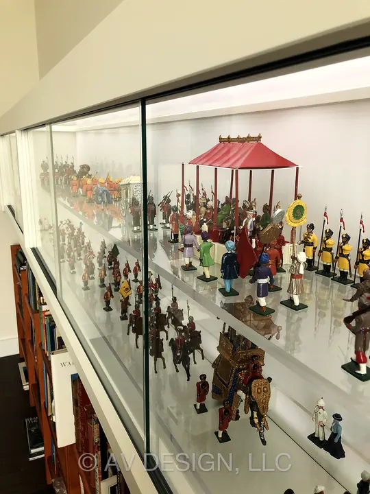 Long built-in display case with sliding glass panels above integrated bookshelves