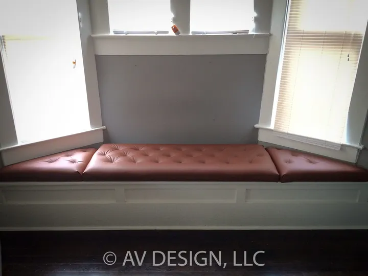 Built-in window seat with leather cushion and white trim
