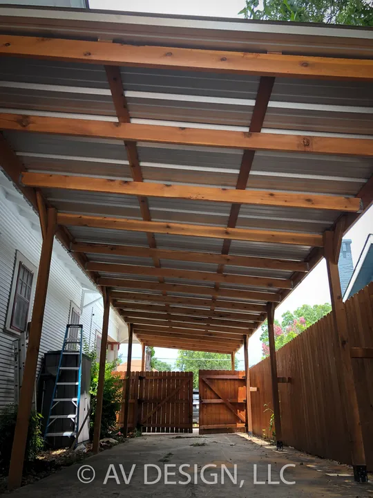 Cedar-framed carport with a metal roof and a gate at the end