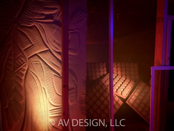 Carved relief panel lit with warm light behind LED tile