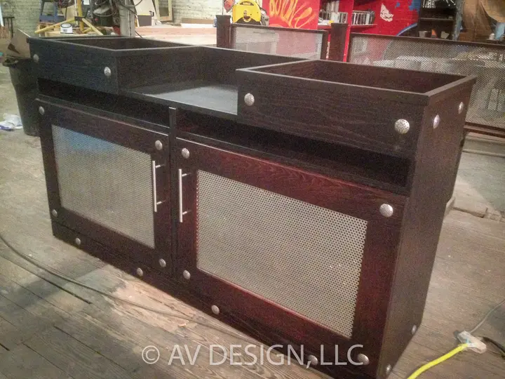 Custom bar cabinet in dark-stained wood with perforated metal doors and chrome pulls
