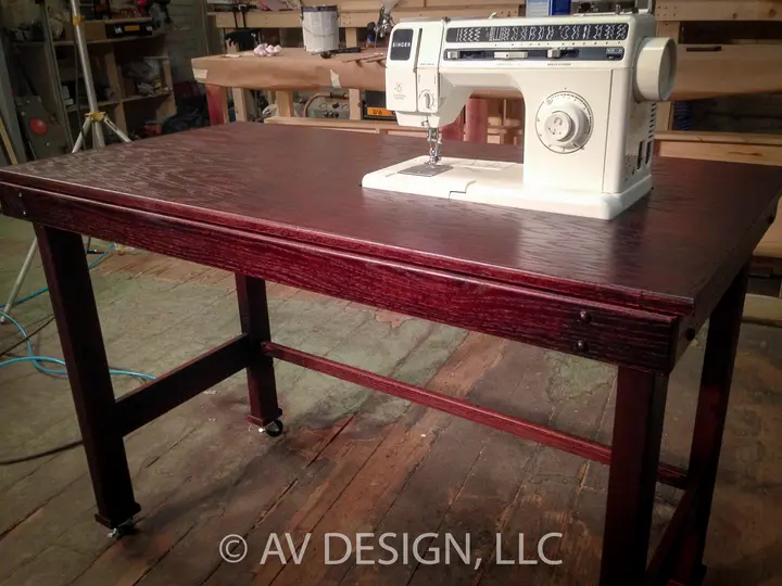 Custom stained oak work table with a pull-out drawer and locking casters