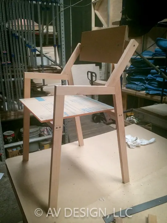 Prototype wood chair with an angled back, built from our own drawings
