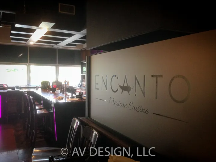 Restaurant bar with an etched glass logo sign and a coffered ceiling
