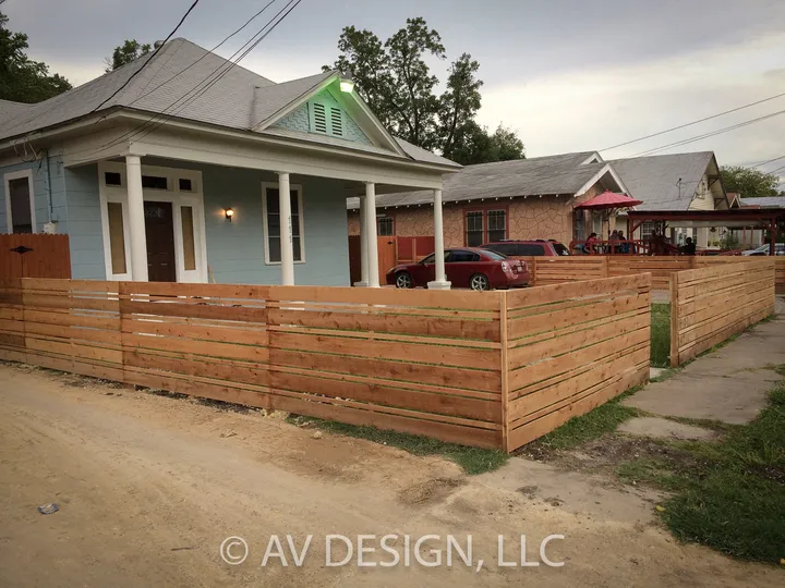Horizontal cedar slat fence in front of a San Antonio bungalow