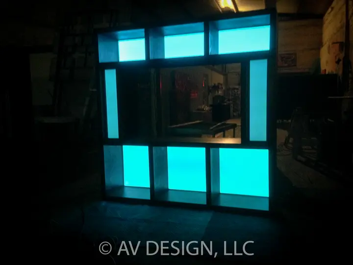 Custom built-in TV wall unit with illuminated cyan and white panels