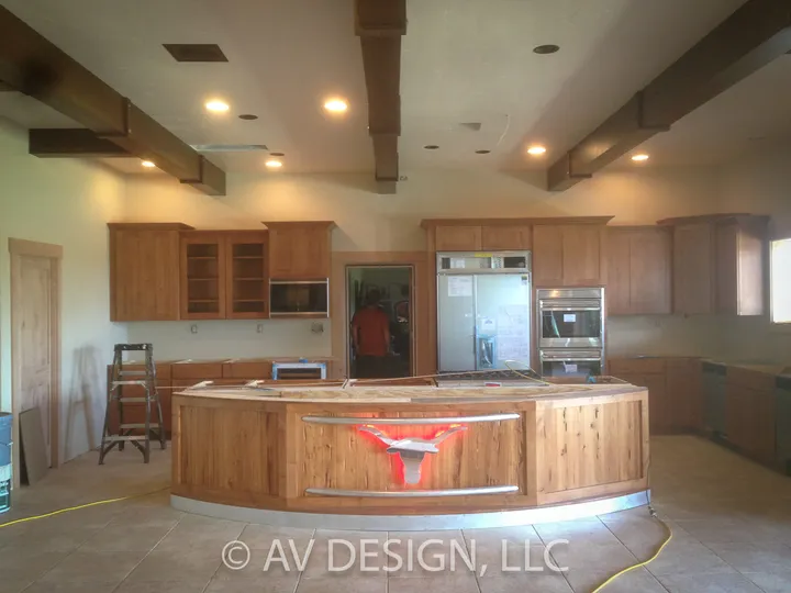 Kitchen with a curved wood island featuring a metal longhorn inlay