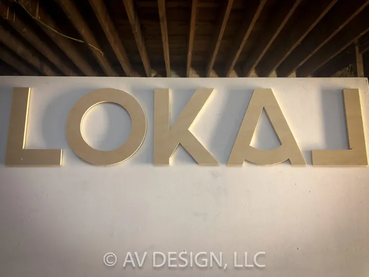 Dimensional wood letters spelling LOKAL on a wall