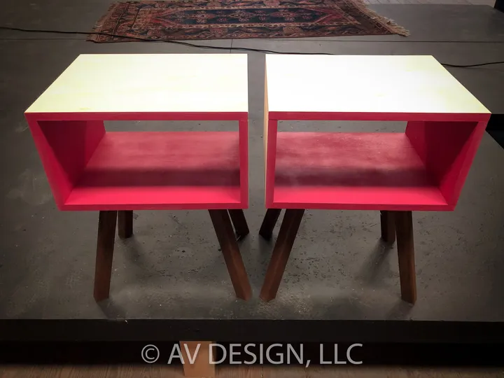 Pair of pink-lined plywood side tables on walnut legs