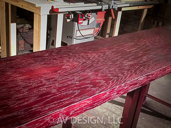 Red-stained open-grain oak bench top in the shop