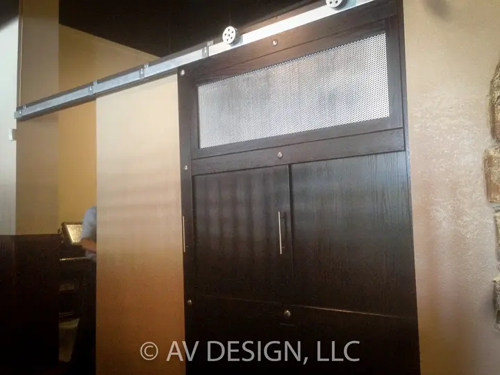 Dark-stained oak cabinet with sliding barn-door hardware and a textured glass transom