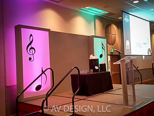 Stage set with backlit cutout panels and a custom podium