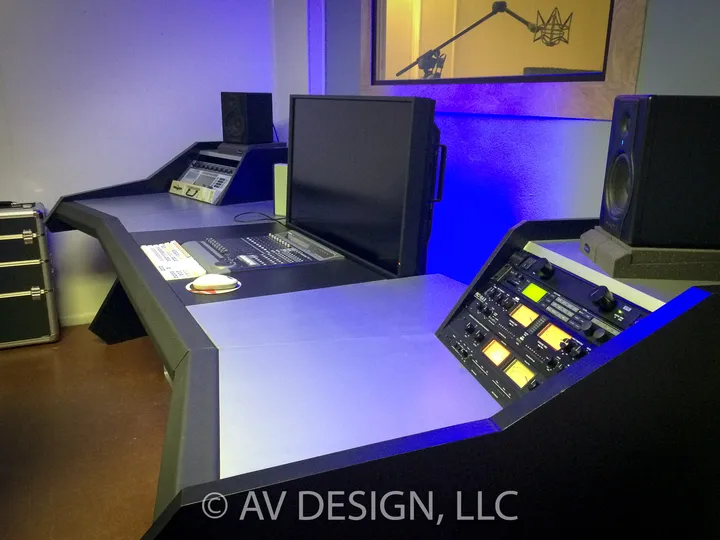 Curved studio desk with a mixing surface under blue light