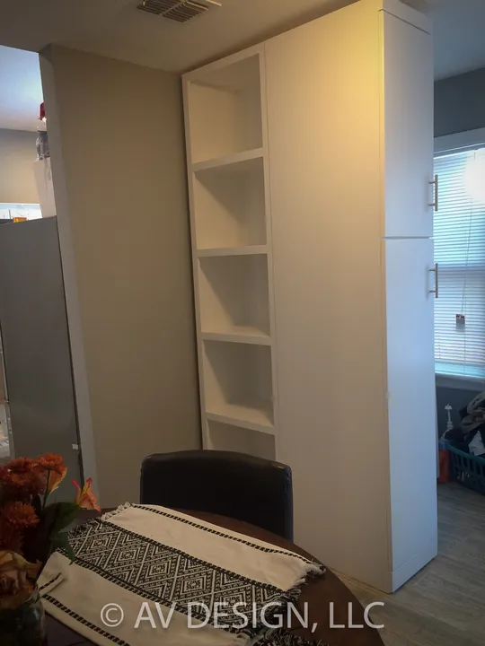 Tall white built-in storage cabinet with open shelves