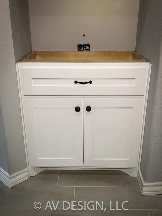 White shaker base cabinet with a drawer, two doors and black pulls