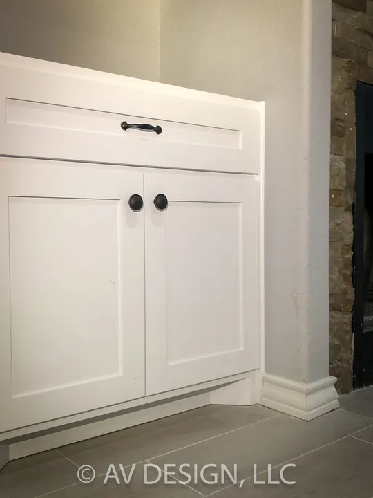 White shaker cabinet fitted into a corner with black hardware